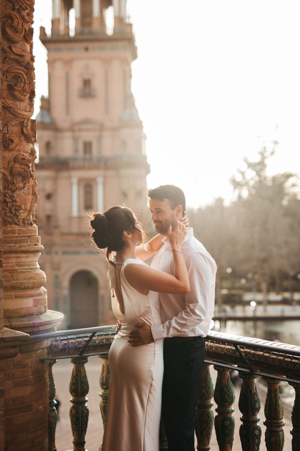 Sunset engagement session at Plaza de España with dramatic architectural backdrop.
