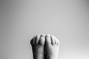 A series of black and white close-up photographs showing hands joined to form different shadow-like shapes and gestures.