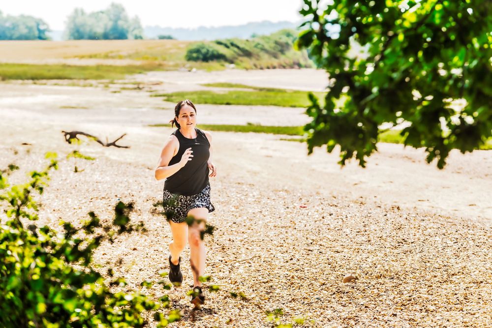 Lifestyle branding portrait of Kate Cotterill running along the Suffolk estuary at Holbrook.