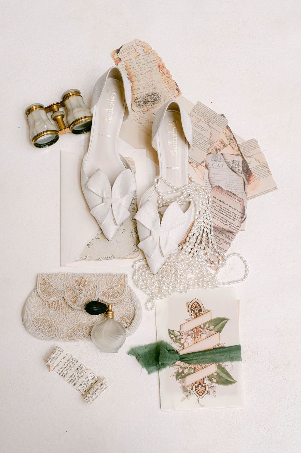 Wedding accessories including delicate lace details, ribbons, and heart decorations arranged on a white surface.