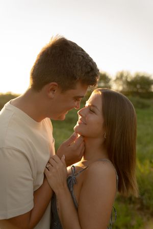 An intimate portrait of a couple in warm sunset lighting outdoors.
