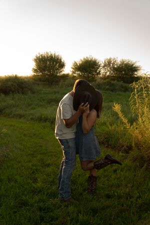 Couple sharing an intimate moment outdoors against a natural backdrop during golden hour.