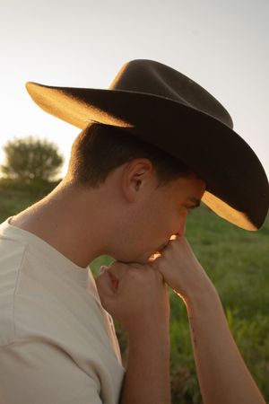 Side view of cowboy hats worn during an intimate moment at sunset.