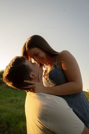 Intimate moment captured in warm sunset lighting with soft focus and natural backdrop.