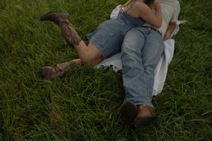 A romantic scene captured in a grassy field during the golden hour.