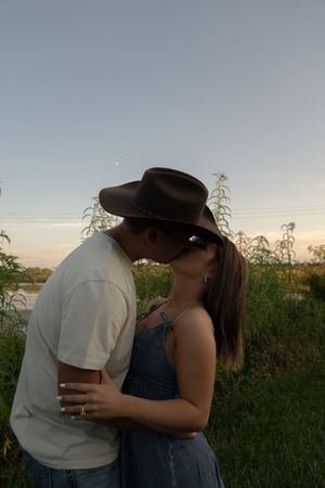 A couple shares an intimate moment outdoors during golden hour.