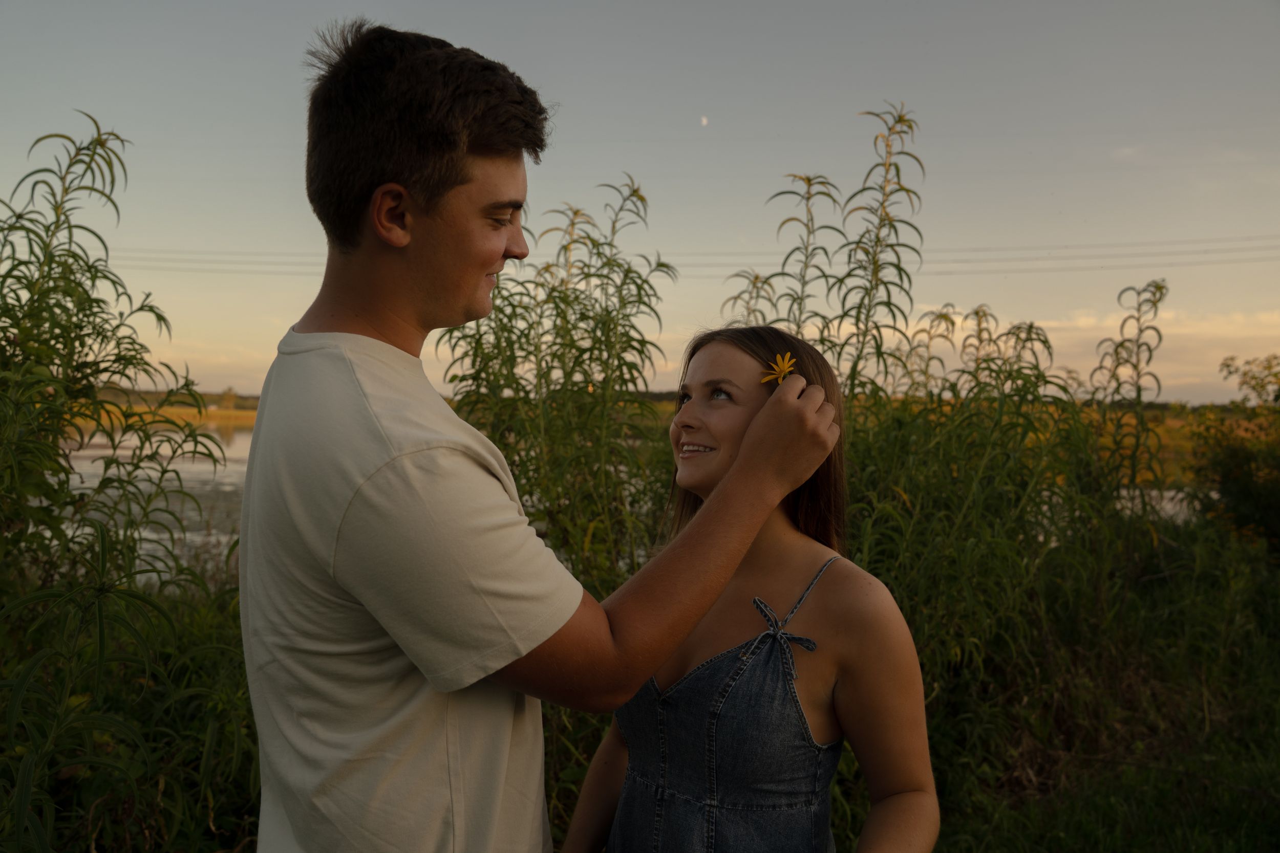 Couple dances together at sunset surrounded by natural prairie landscape.