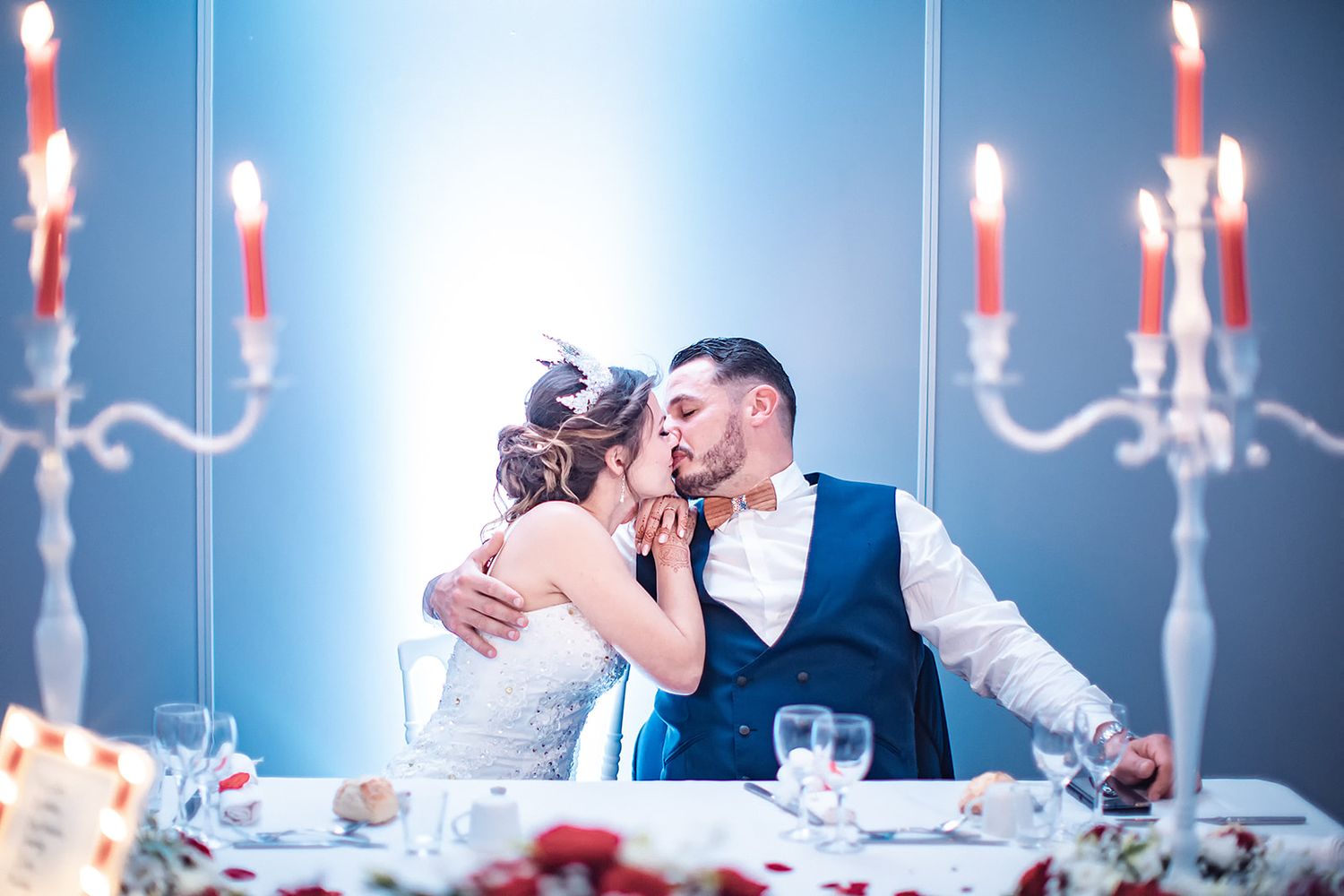 Photographe mariage Montauban – un couple de jeunes mariés s’embrasse tendrement lors du repas de noces, capturé par Laëtitia Klopocki
