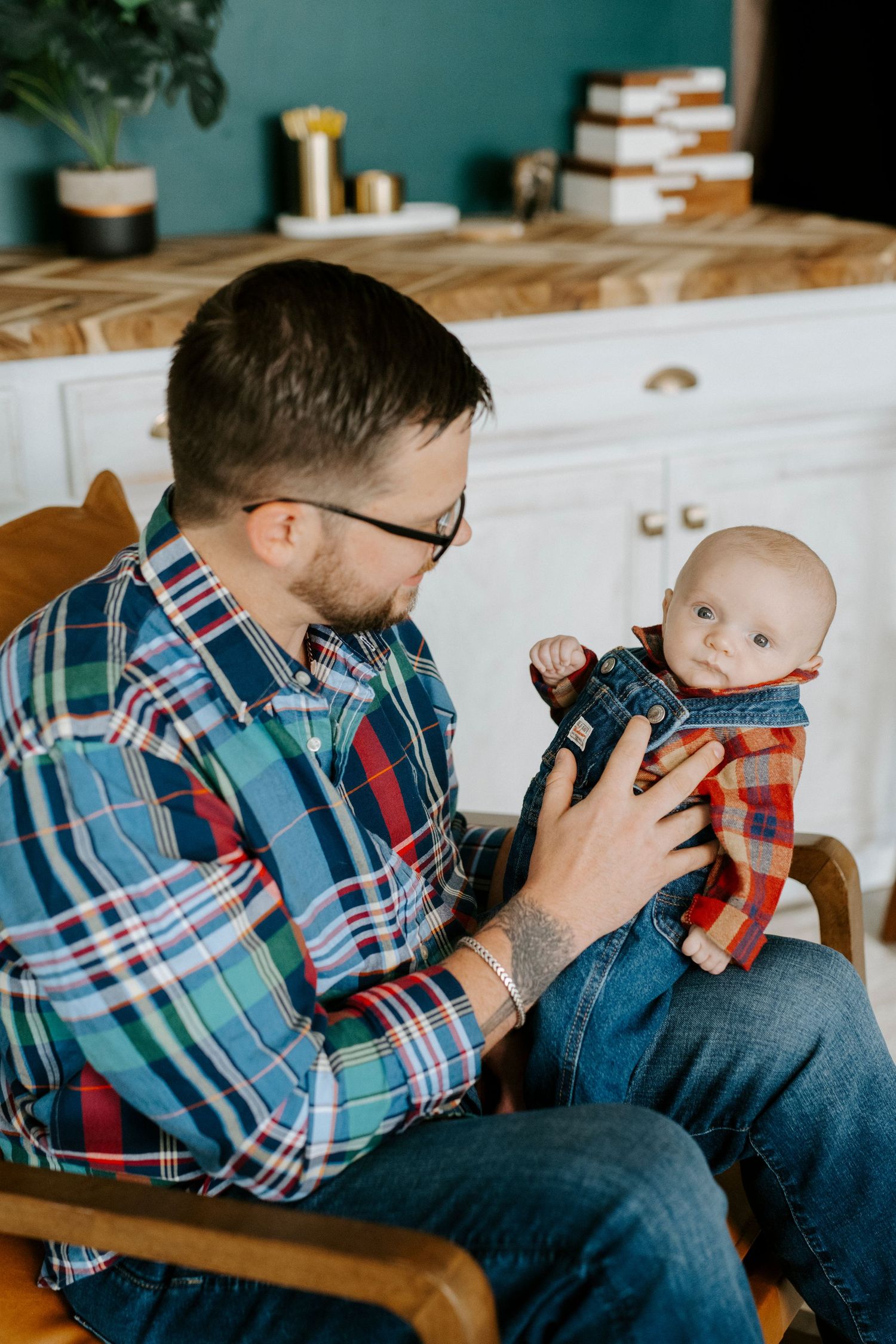A sequence of photos showing a parent in a plaid shirt cuddling with a baby on a couch.