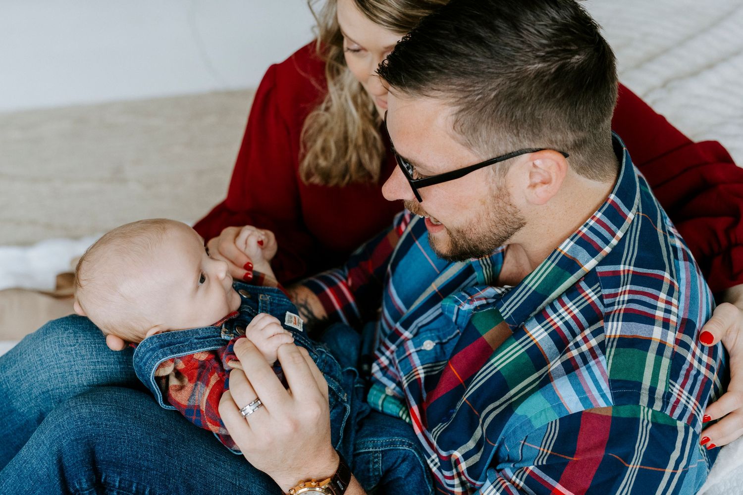 Series of candid moments showing adult and baby bonding together on brown leather armchair in living room.