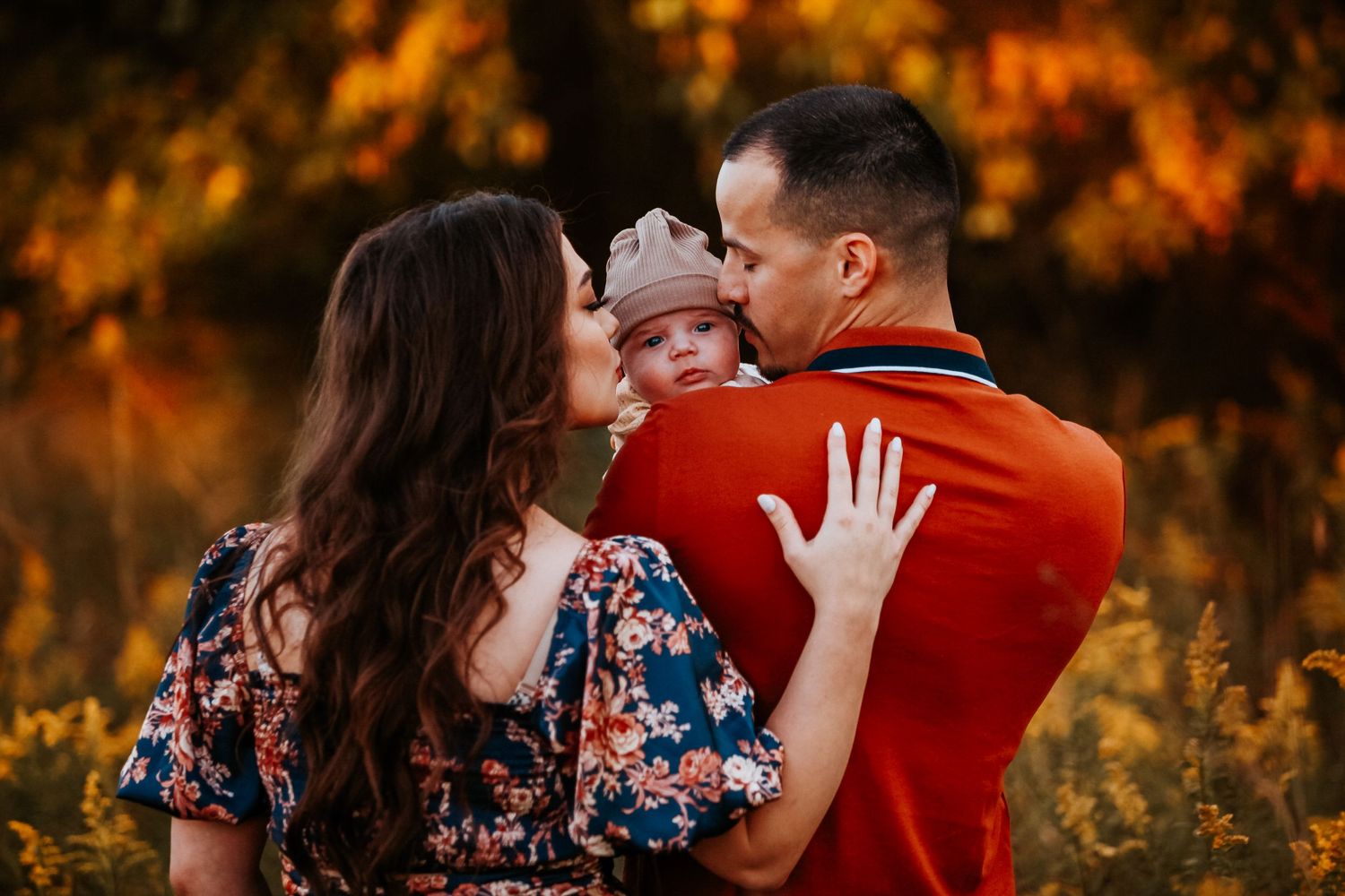 A family shares an intimate moment with their baby during a golden hour photoshoot.