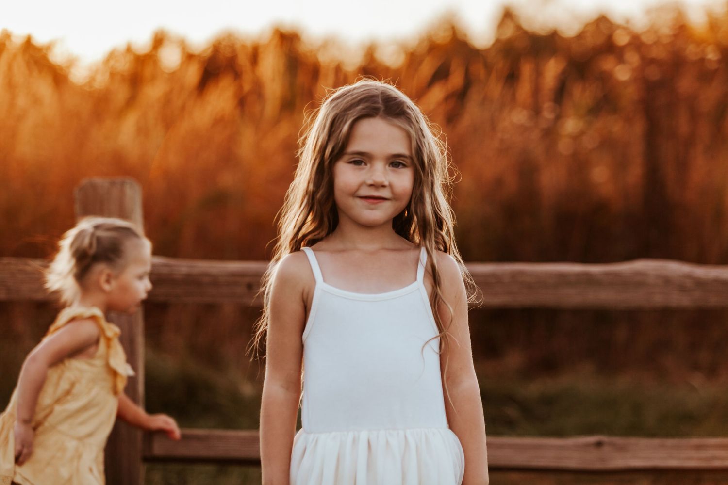 White dress stands out against warm autumn colors in evening sunlight.