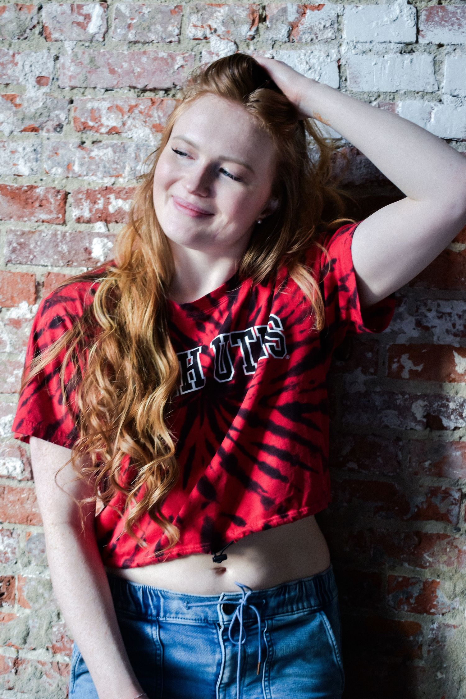 Seattle senior portrait in a casual outfit against a brick wall, perfect for a relaxed look.