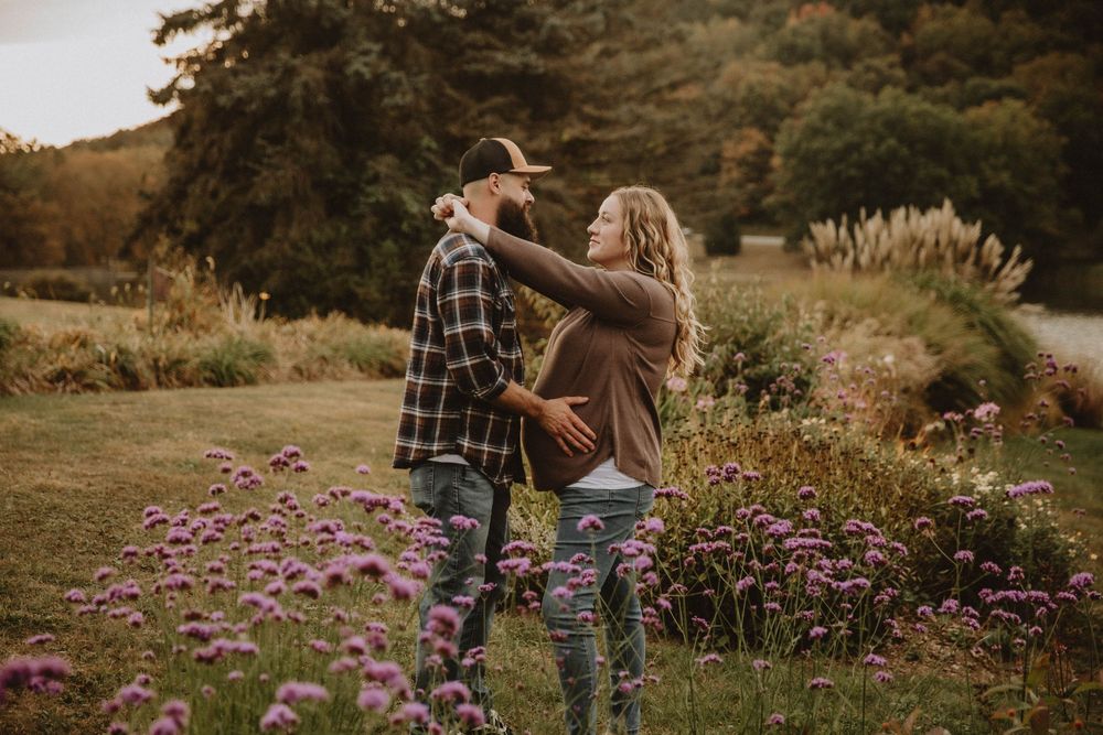 Couple shares intimate autumn maternity photo shoot in field with golden wildflowers at sunset. indiana pa photographer blue spruce park