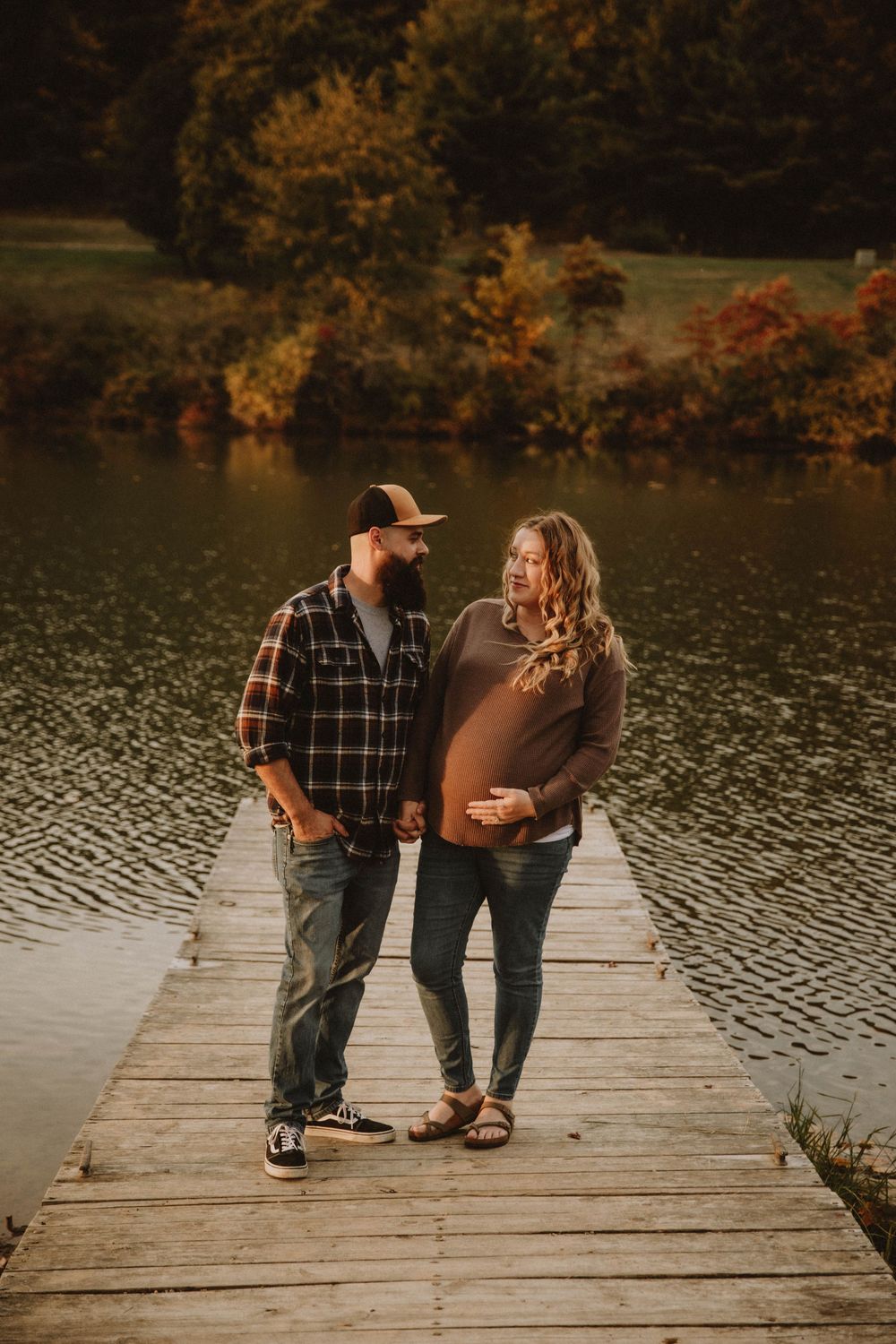 Couple shares intimate autumn maternity photo shoot in field with golden wildflowers at sunset. indiana pa photographer blue spruce park