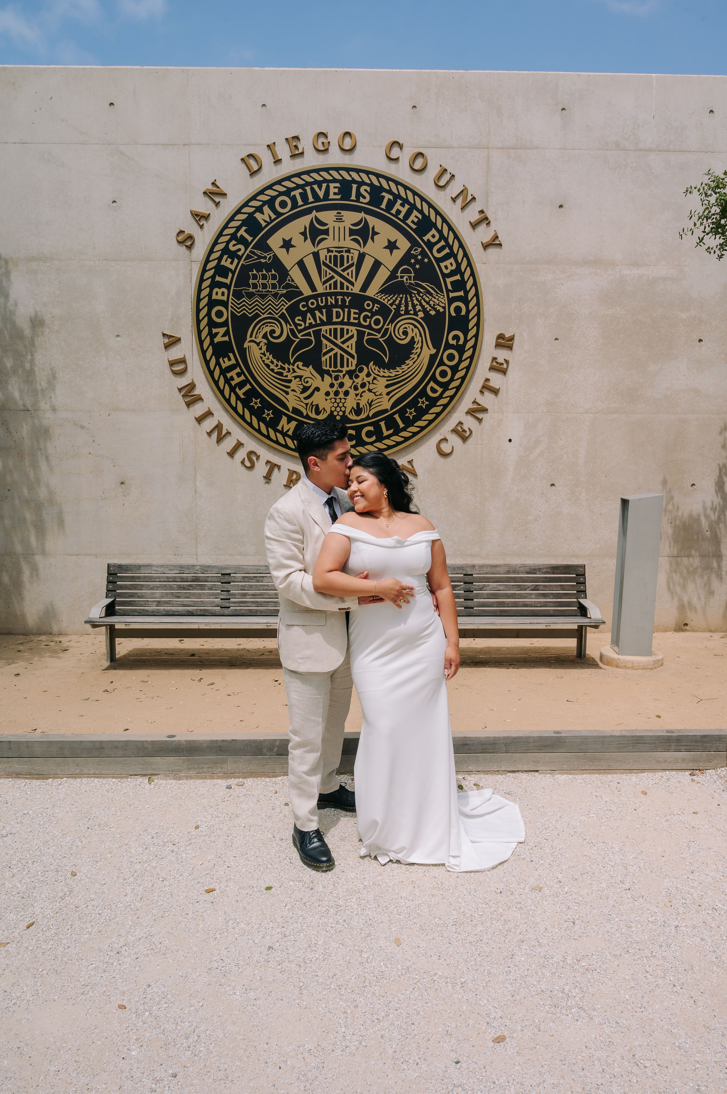 Elopement at the San Diego County Clerks office, couple hugging in front of county clerks seal outside the offices.