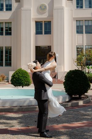 Elopement at the San Diego County Clerks office, couple spinning while man lifts women up in embrace.