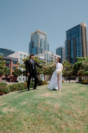 Elopement at the San Diego County Clerks office, couple on grassy hill with city scape in the background after their civil ceremony.