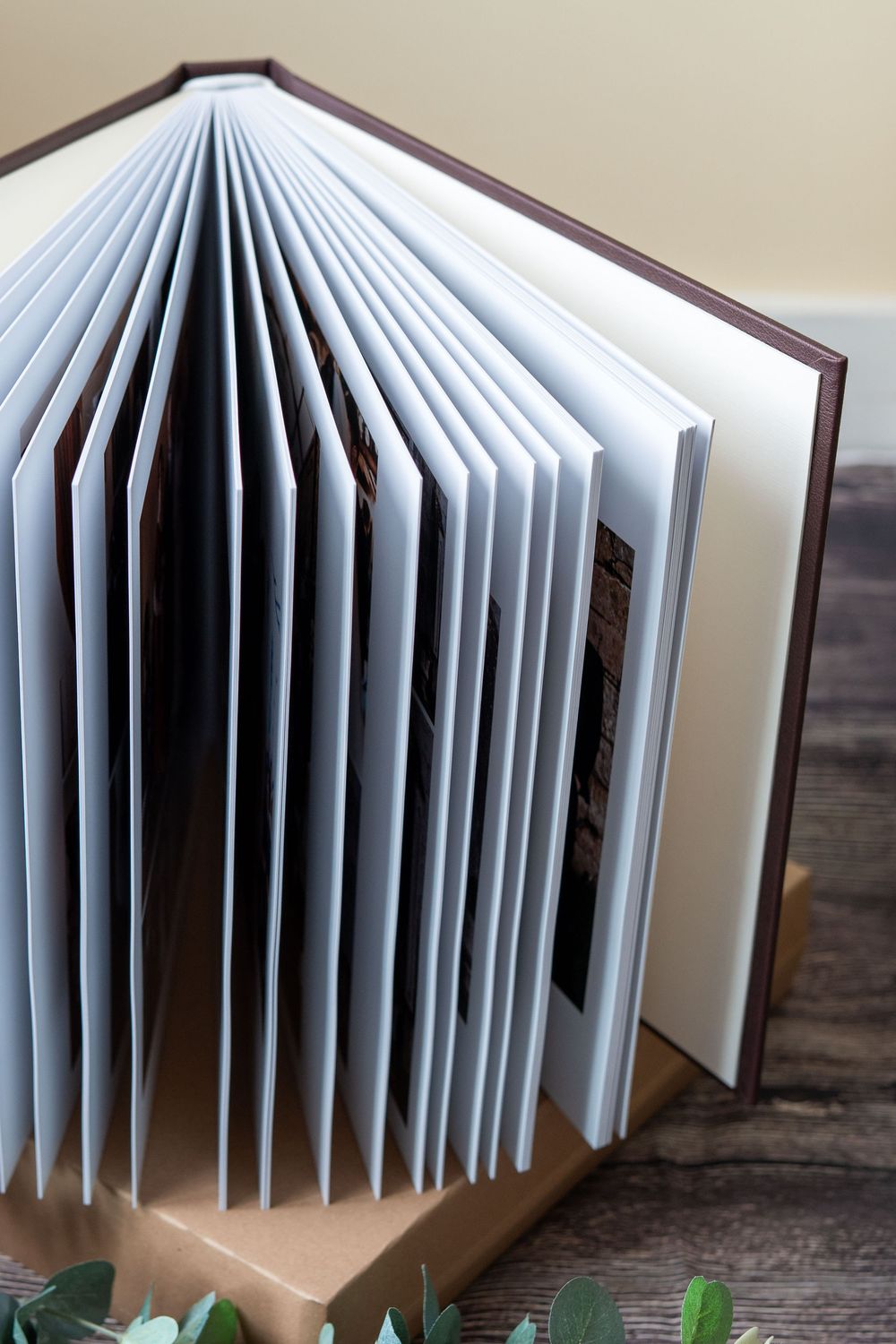 Close-up angled views of white paper pages bound in hardcover book fanning out to show accordion-style folded structure.