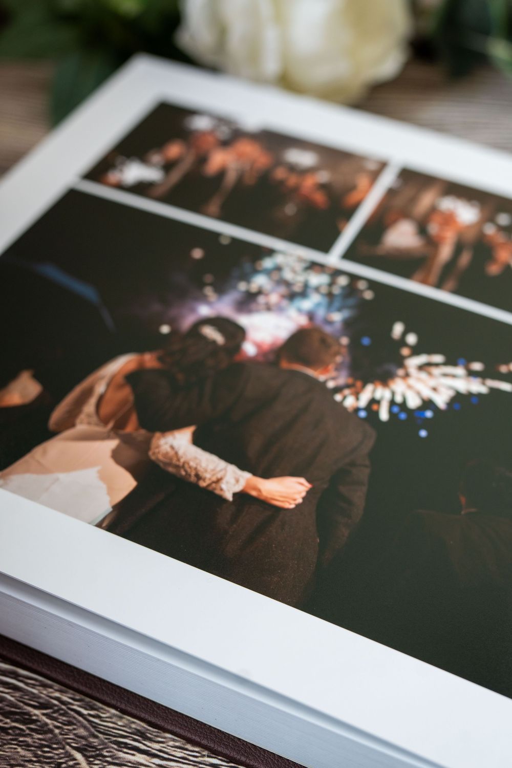 A close-up photograph of a photo album page showing sparklers and festive moments at a nighttime celebration.