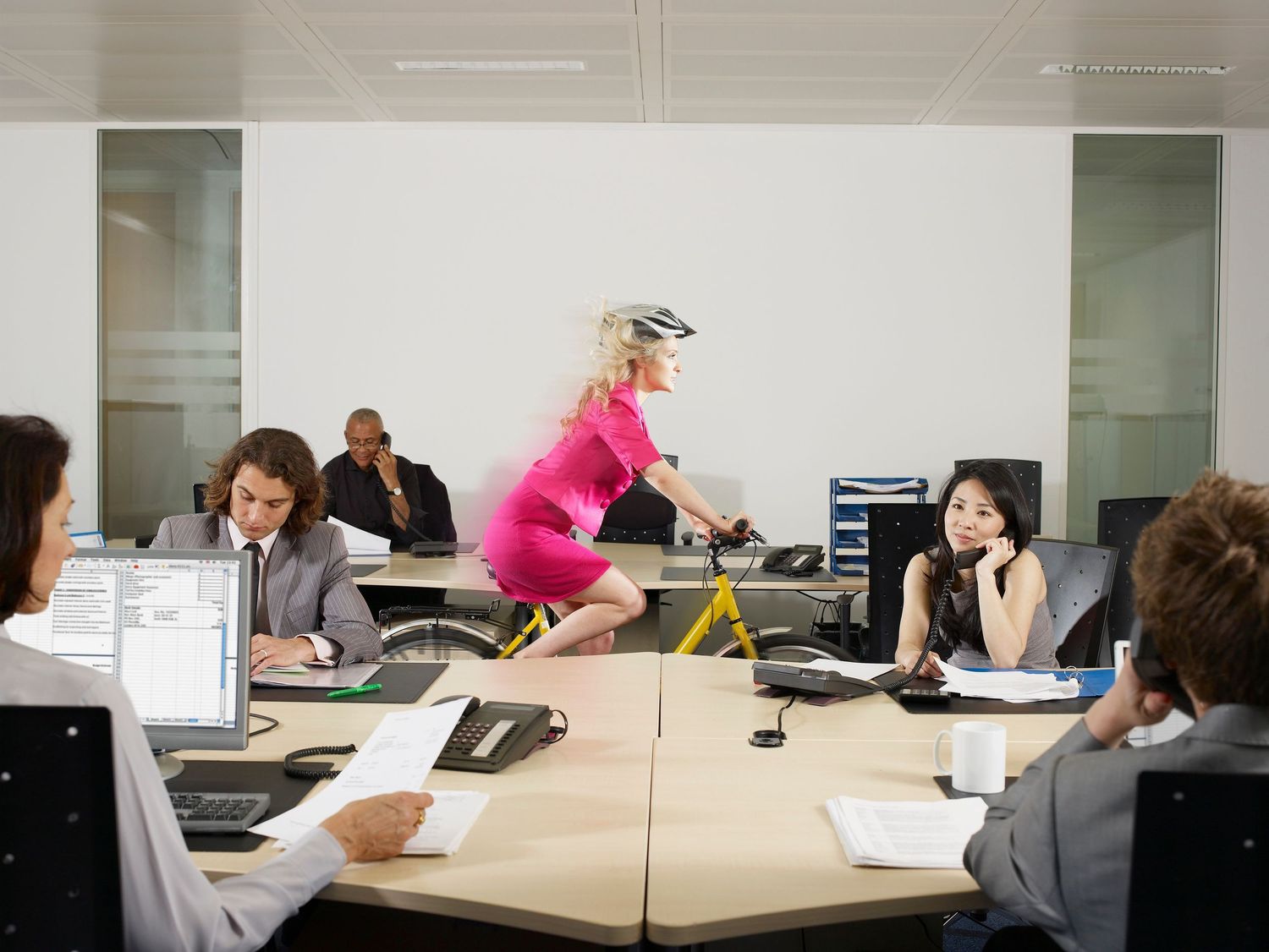 Business professionals collaborate in a modern office conference room around a large white meeting table.