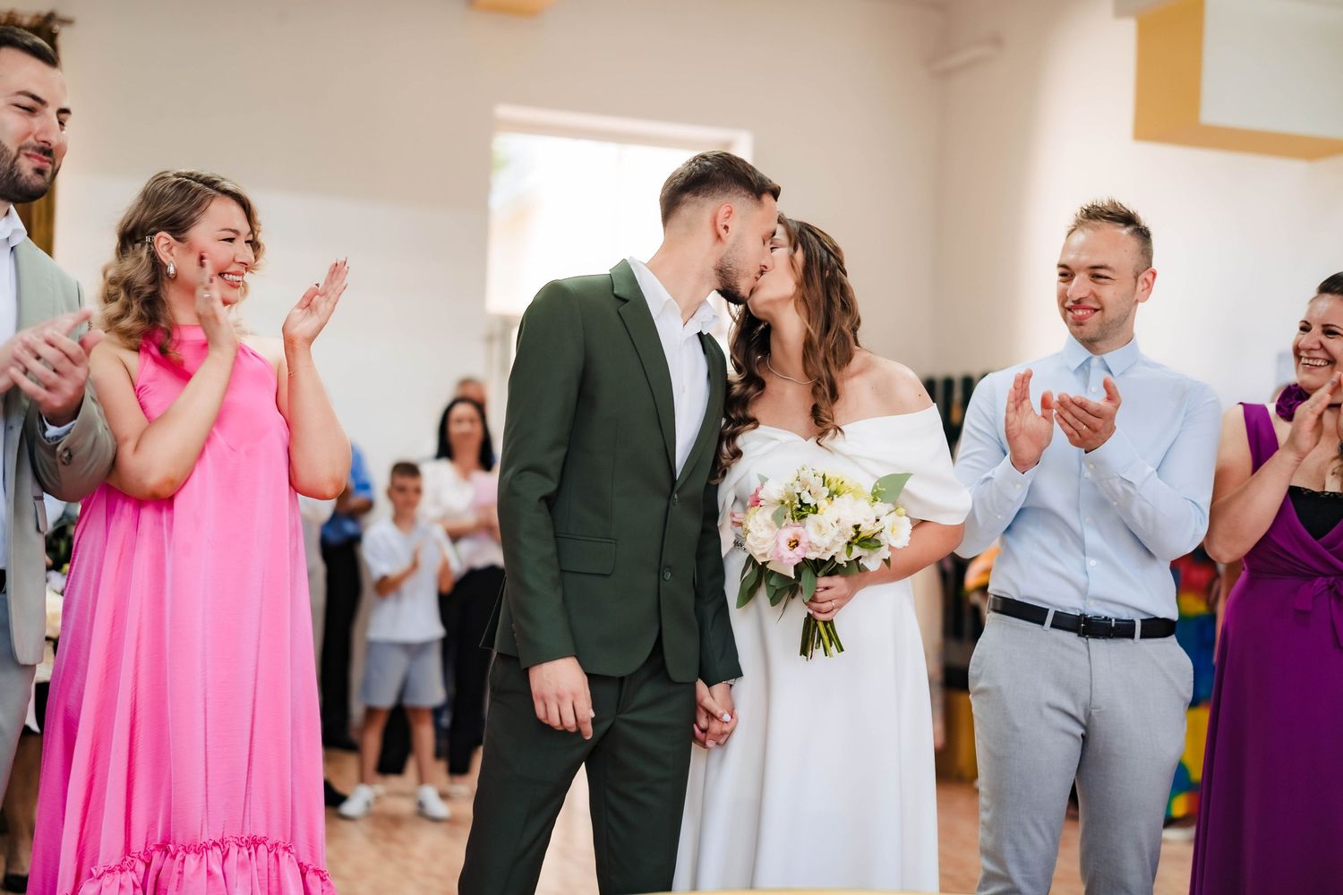 Wedding celebration with guests dancing and mingling in an indoor reception space.