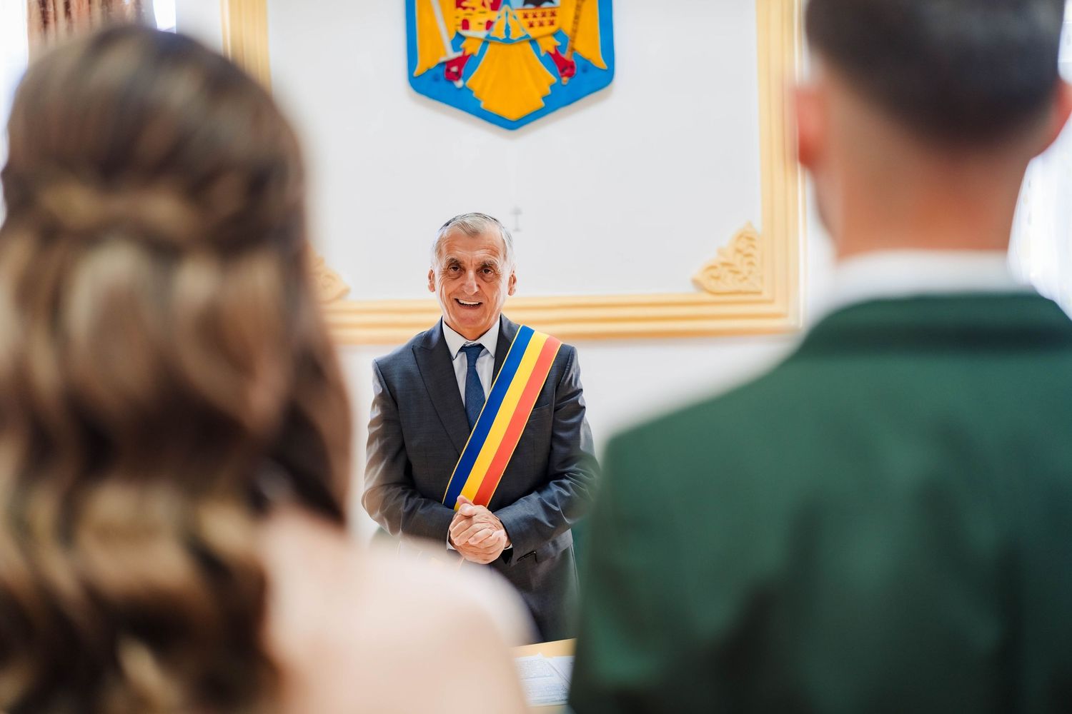 Official ceremony taking place in a government building with Romanian flags and coat of arms visible.