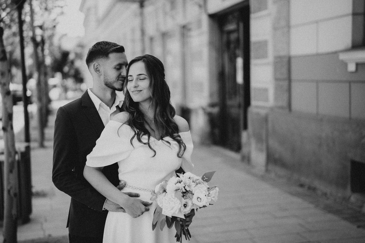 Classic black and white wedding portraits taken in an urban setting with architectural elements.