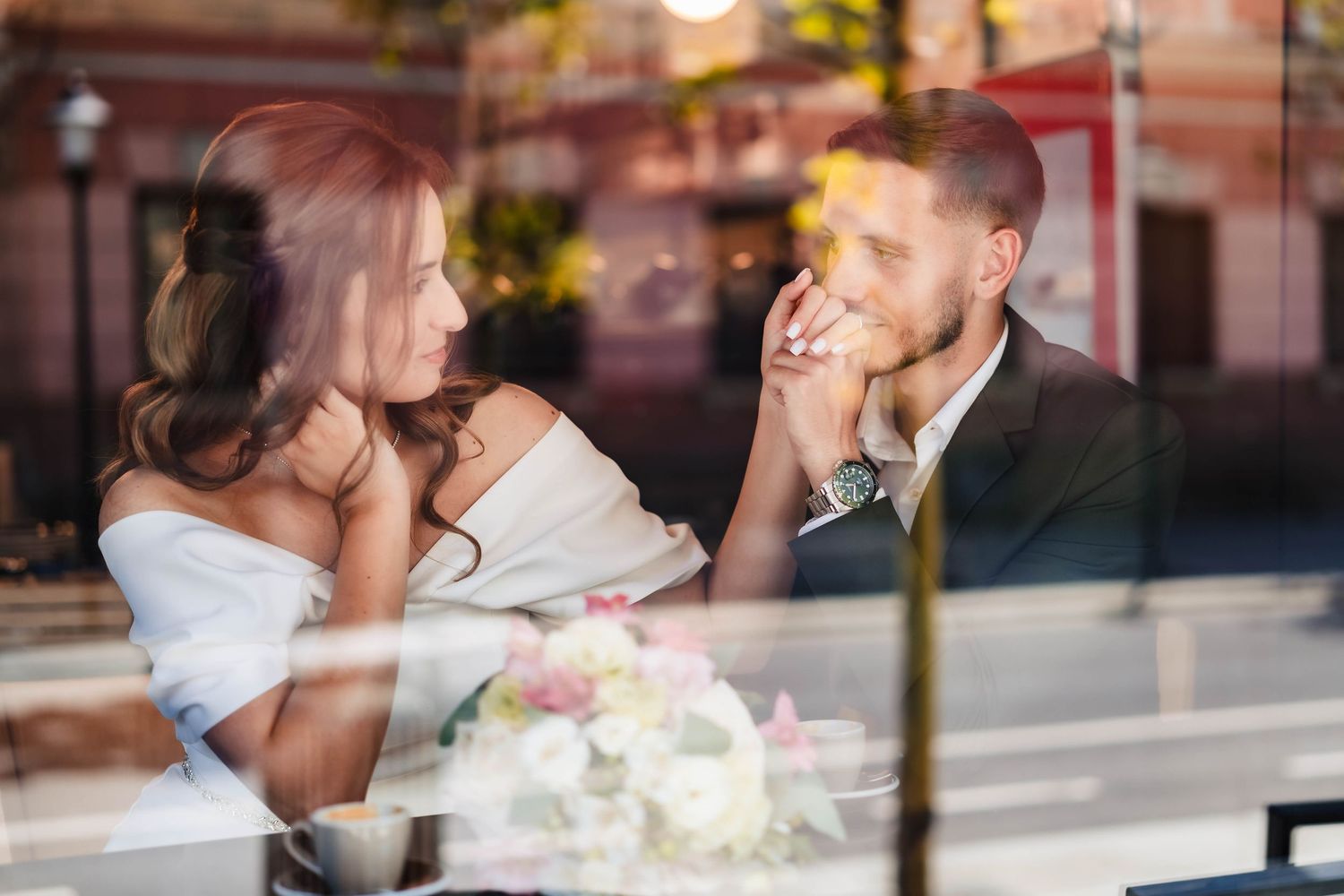 Wedding celebration scene through window reflections at sunset.