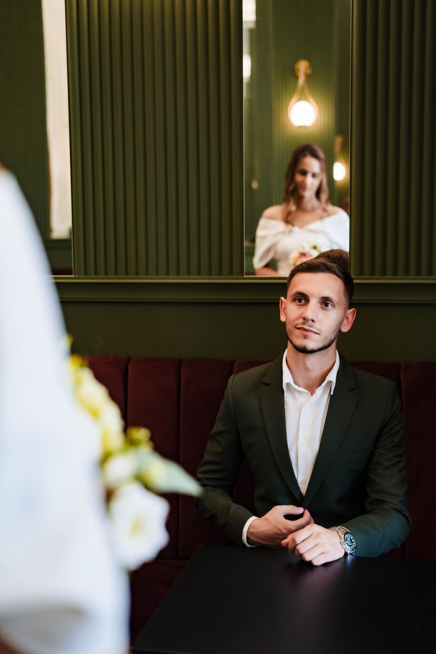 Formal portrait sequence in dimly lit room with green walls and ambient lighting.