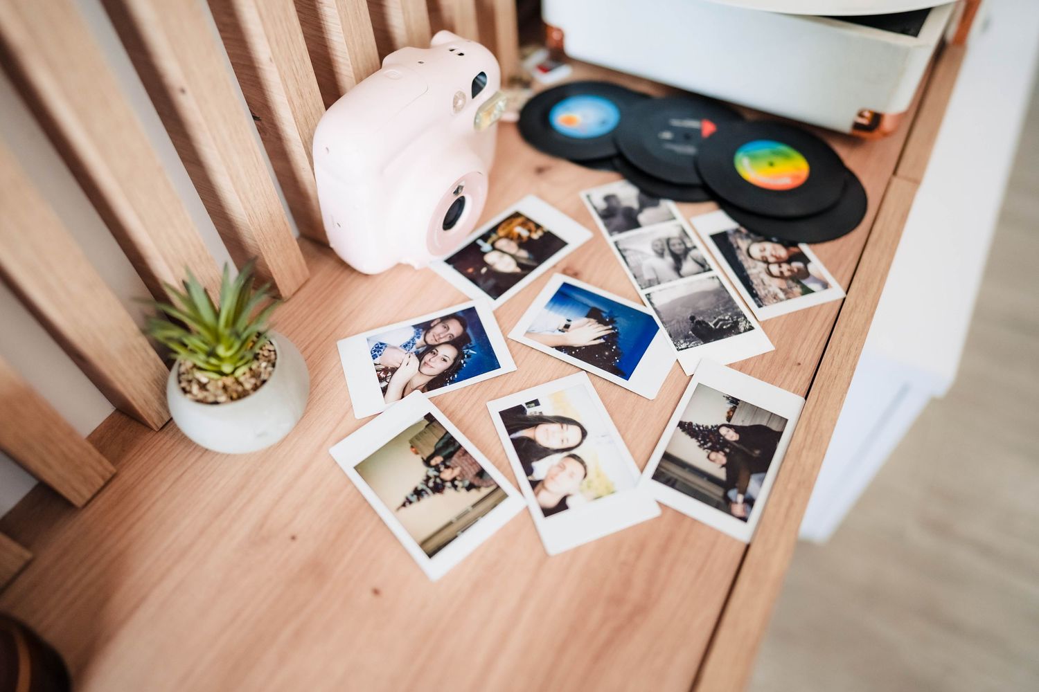 Collection of polaroid photos and memorabilia arranged on wooden surface.