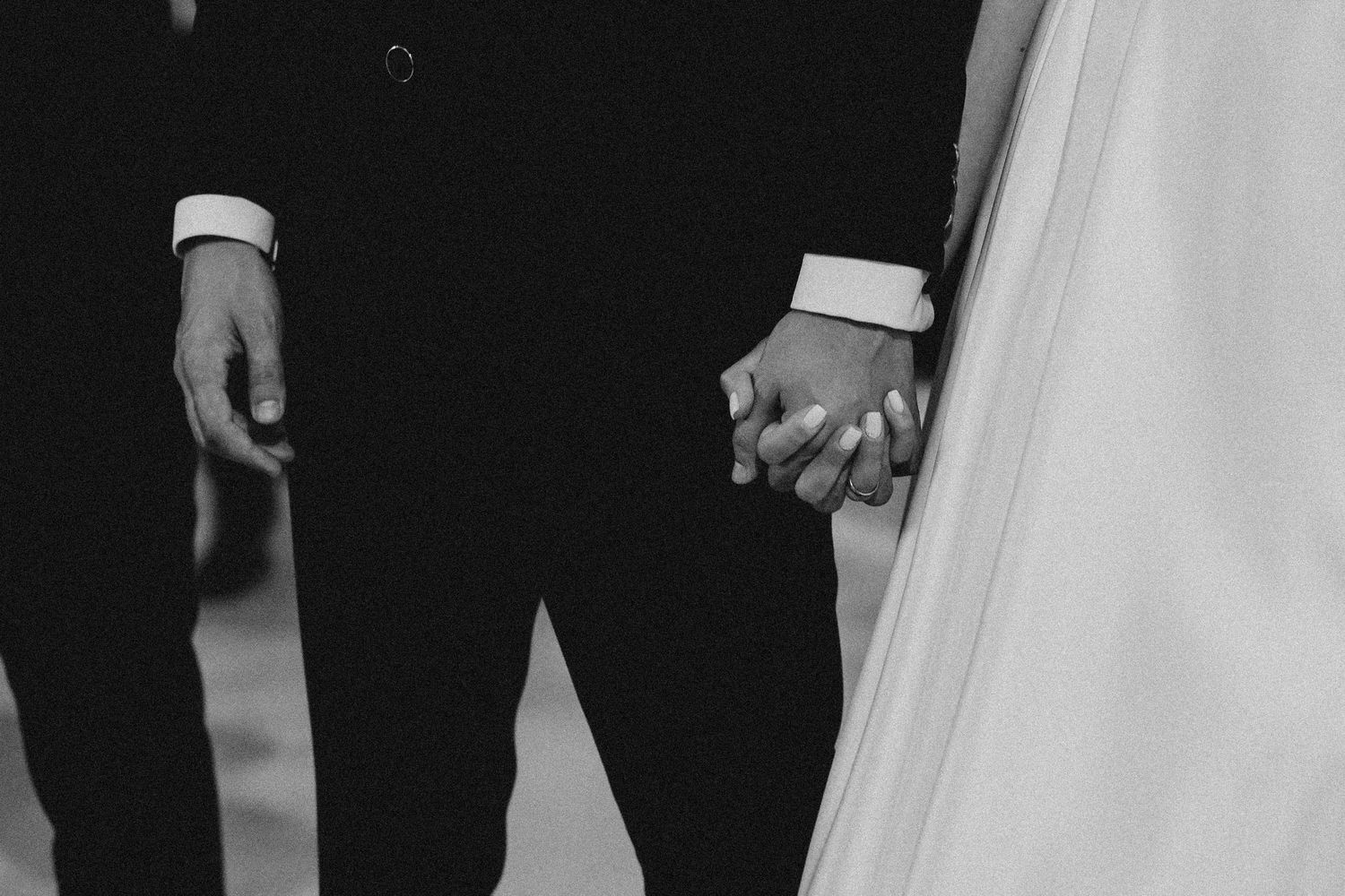 Black and white photo showing formal attire details at wedding ceremony.