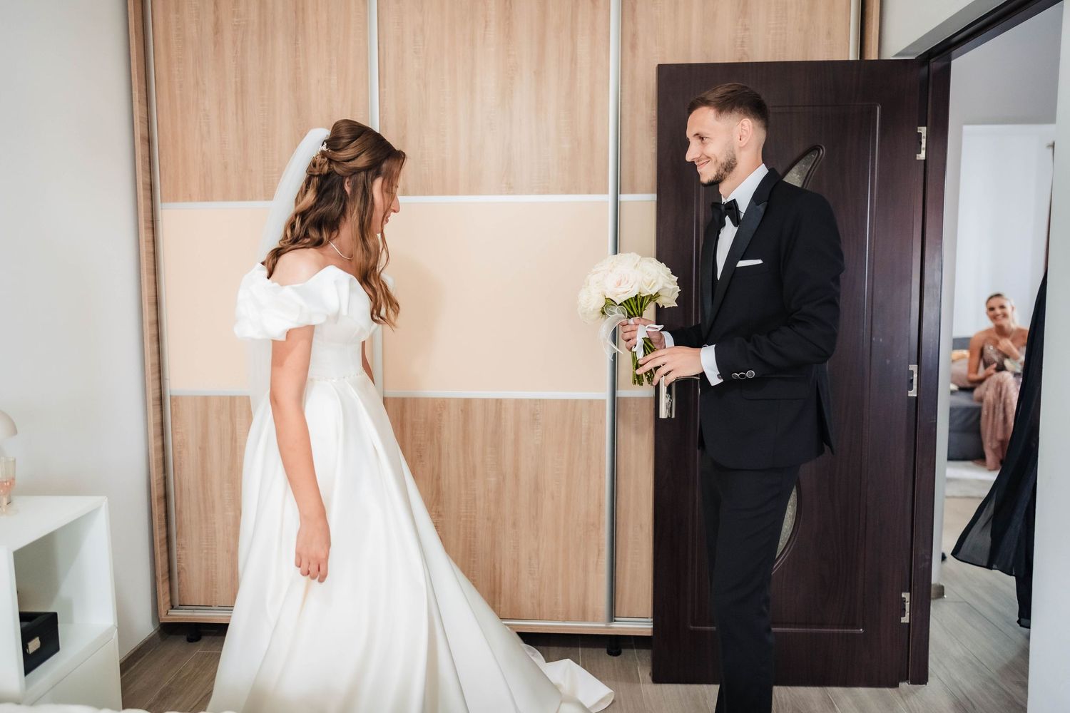 Wedding preparations in a modern hotel room with wood paneled walls.