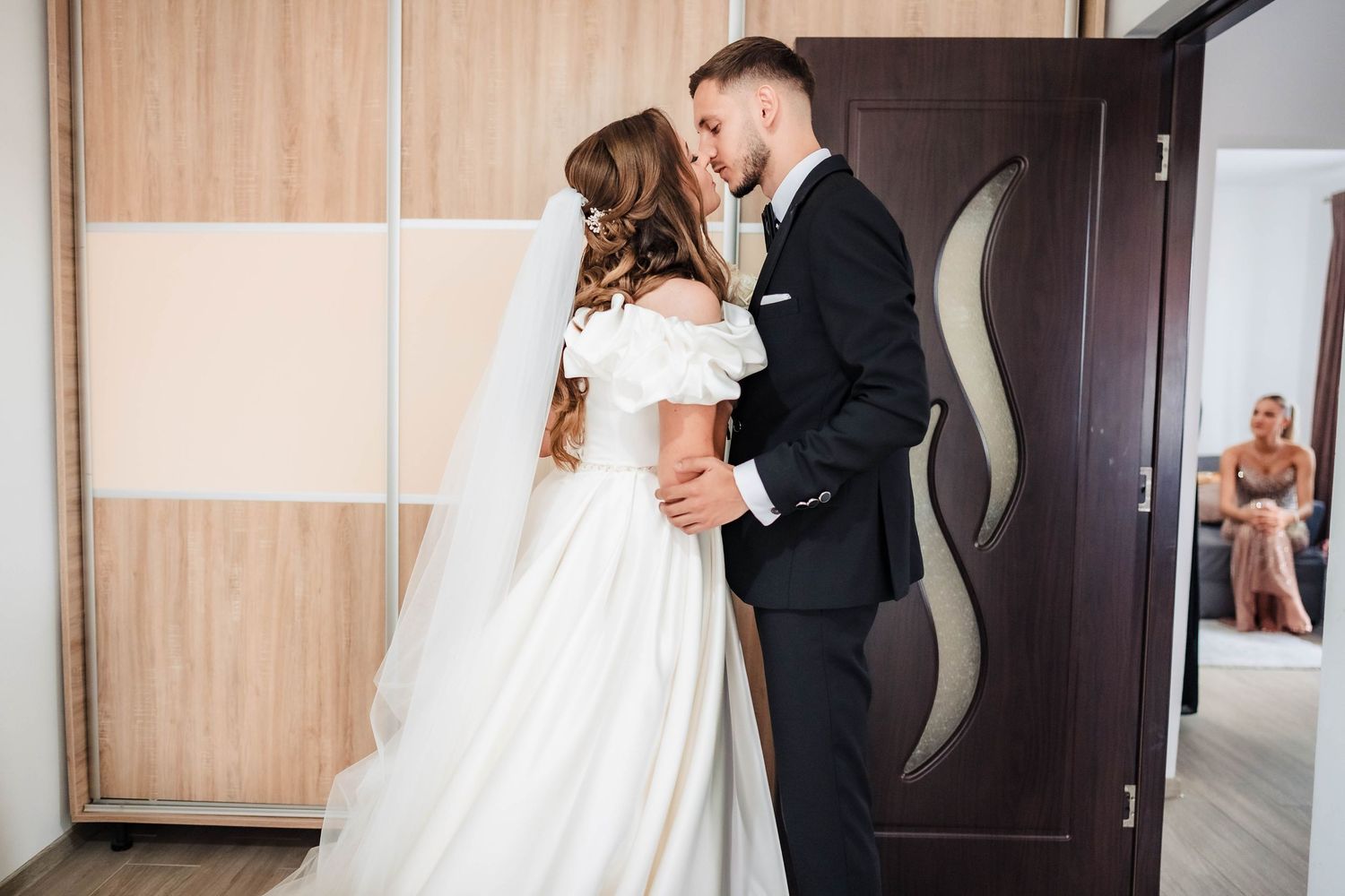 First look moment between couple in formal wedding attire in a hotel hallway.