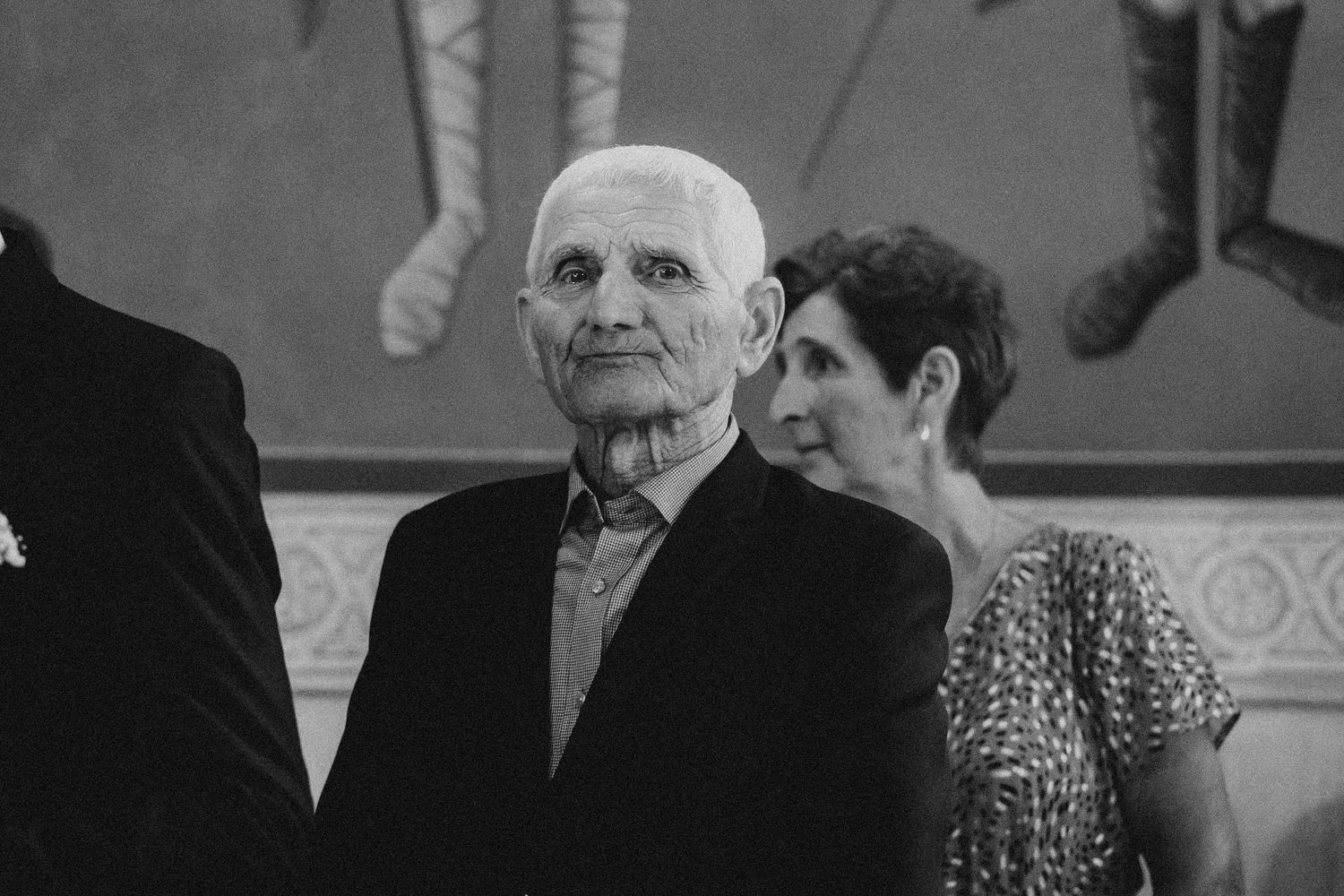 Black and white photo of wedding guests during an emotional ceremony moment.