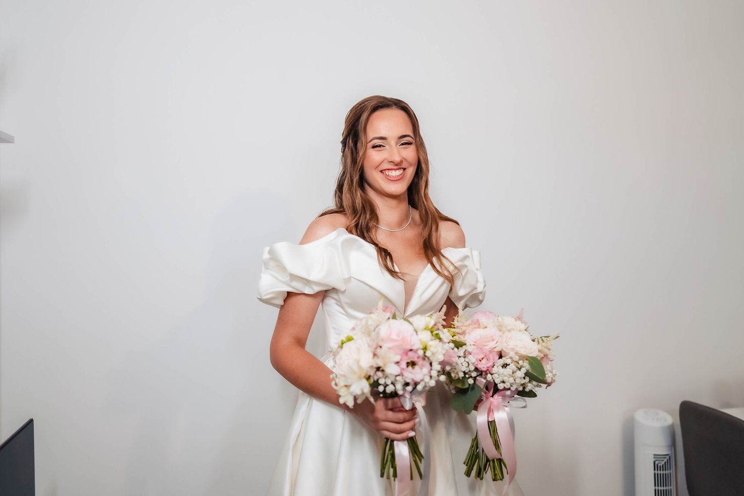 Bride holding beautiful floral bouquet with pink and white flowers.