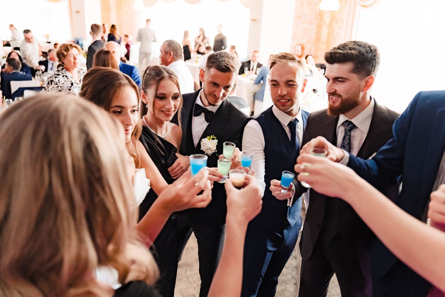 Wedding guests raising glasses for a celebratory toast at reception.