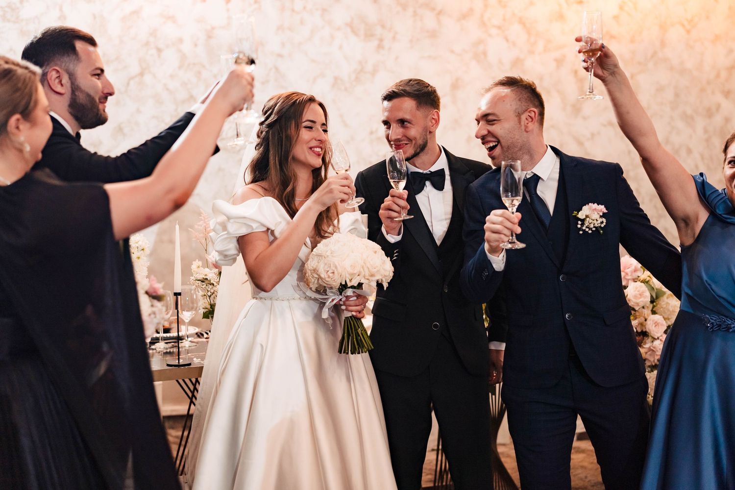 Wedding celebration with guests cheering and dancing in an elegant ballroom setting.