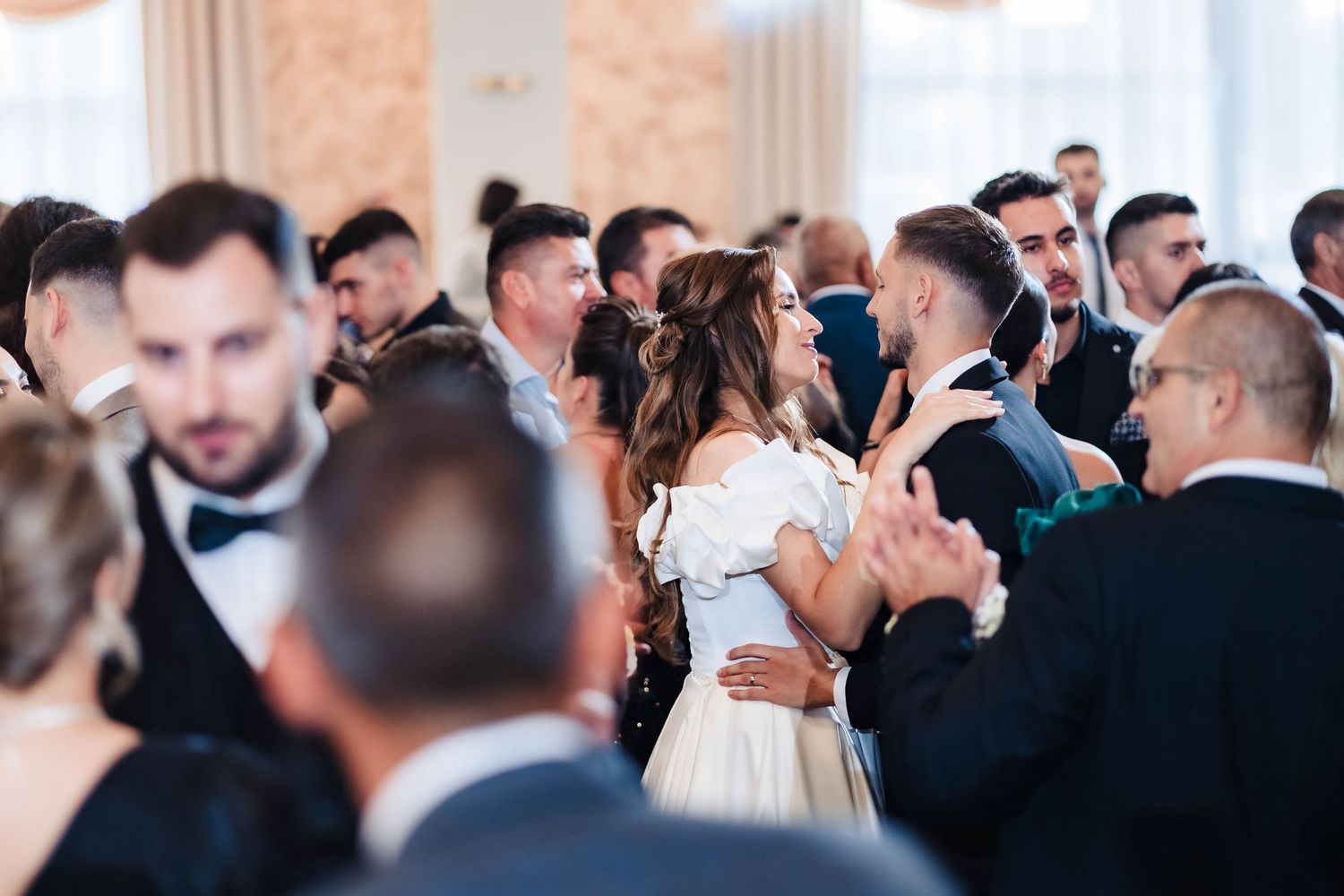 Elegant wedding reception with guests mingling in a beautifully decorated ballroom.