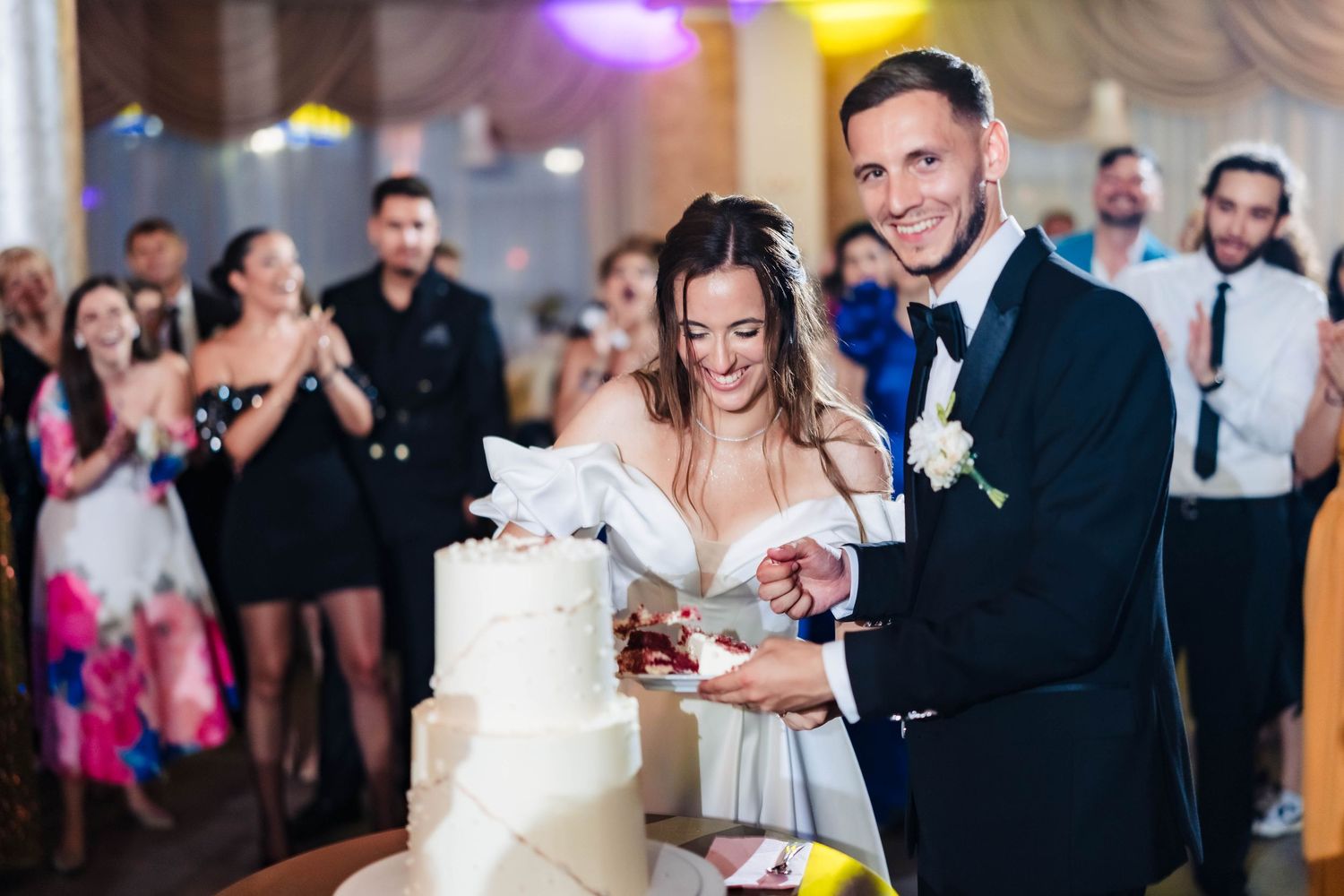 Wedding reception featuring joyful dancing and celebration with colorful lighting effects.