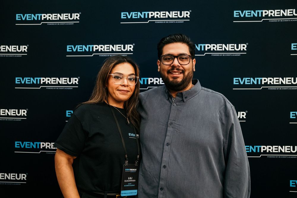 Professional event photography backdrop featuring repeating Eventpreneur branding text in blue and white design.