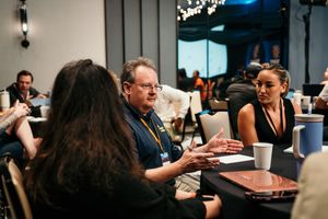 Business professionals engage in focused discussion around a conference table during a corporate meeting.