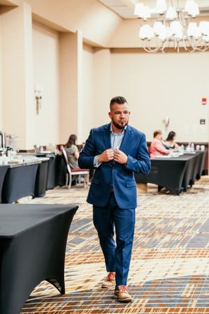 A sequence of photos showing a person in a blue suit sitting and checking their phone in an elegant event space.