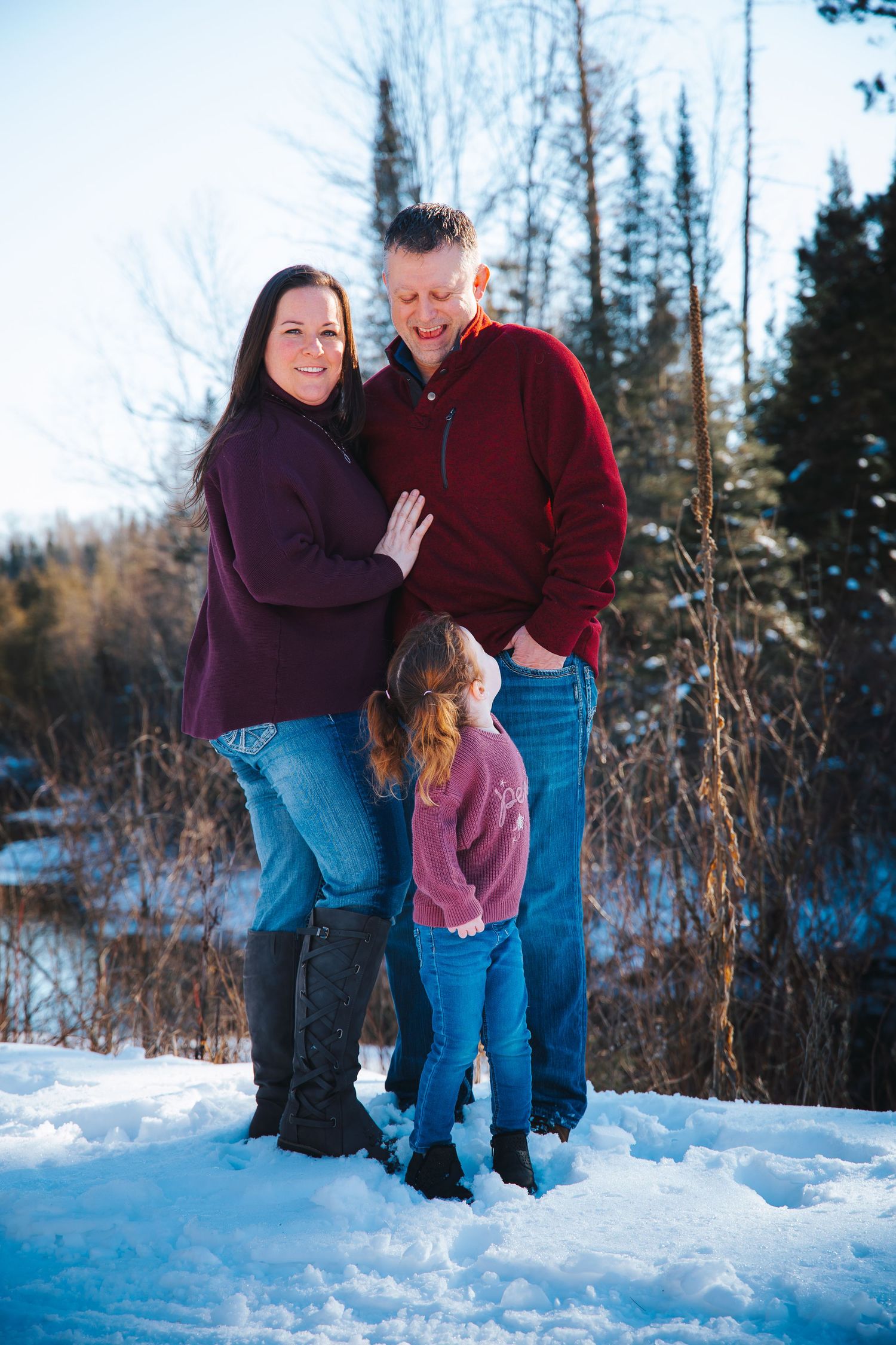 Winter photo sequence of couple playing in snow with evergreen trees in background.