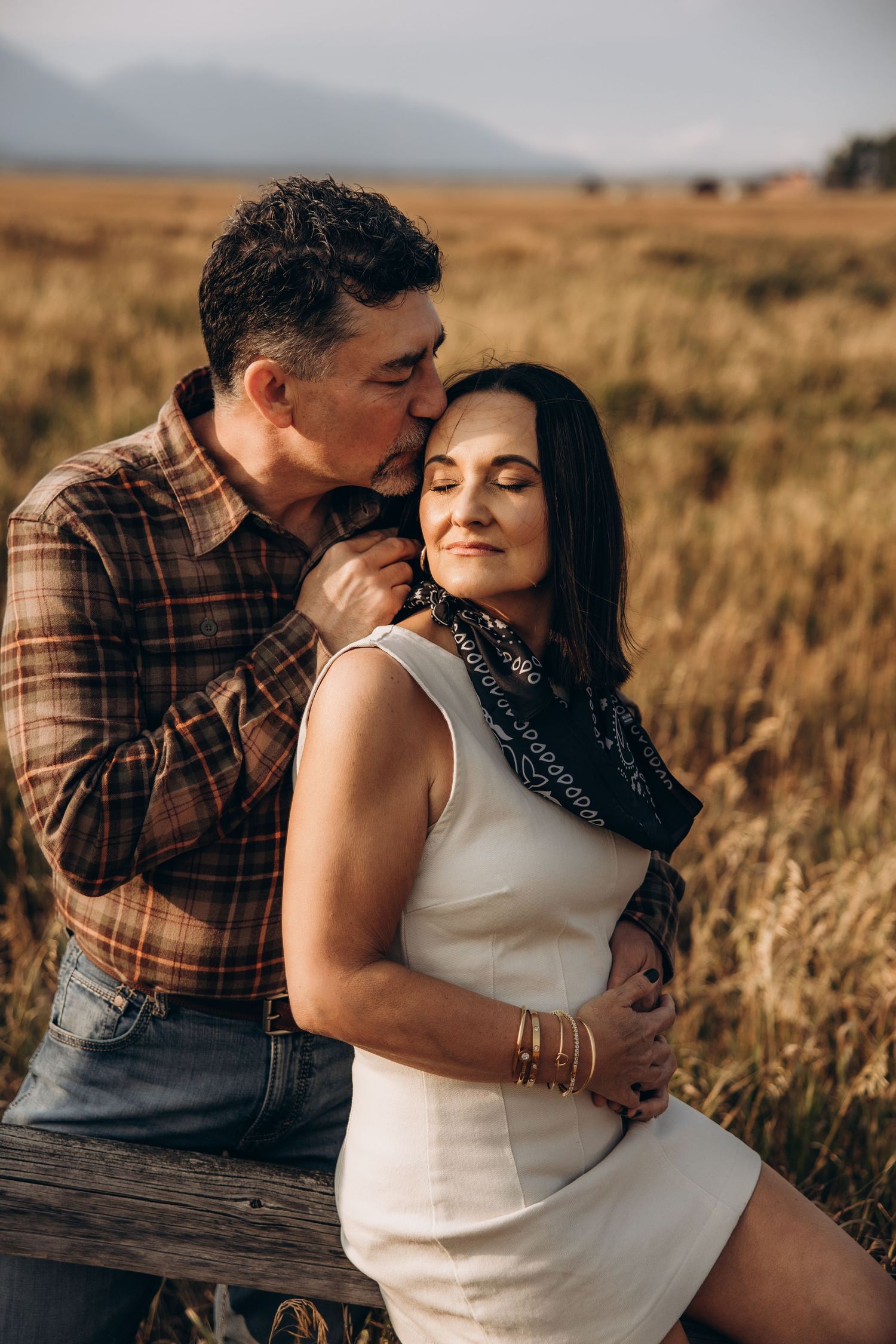 A romantic photo series showing a couple embracing in a golden wheat field at sunset.
