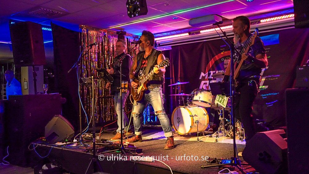 Colorful purple and blue LED lighting illuminates a nightclub or bar interior during an evening event.