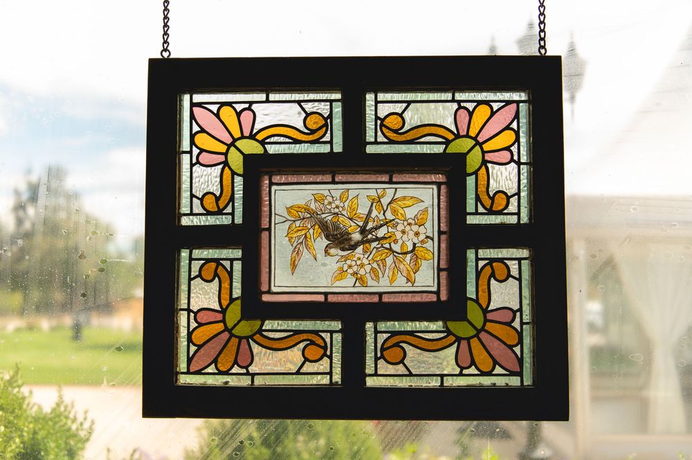 Decorative stained glass window panels featuring geometric patterns in orange, yellow and clear glass with black borders.
