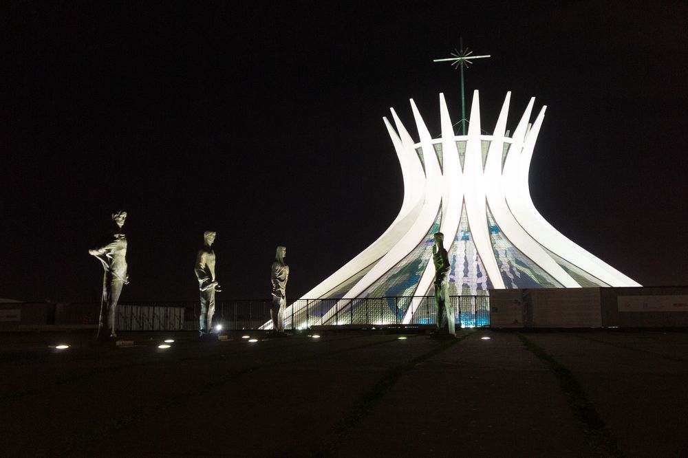 Cathedral of Brasilia glows with dramatic illumination against the dark night sky.