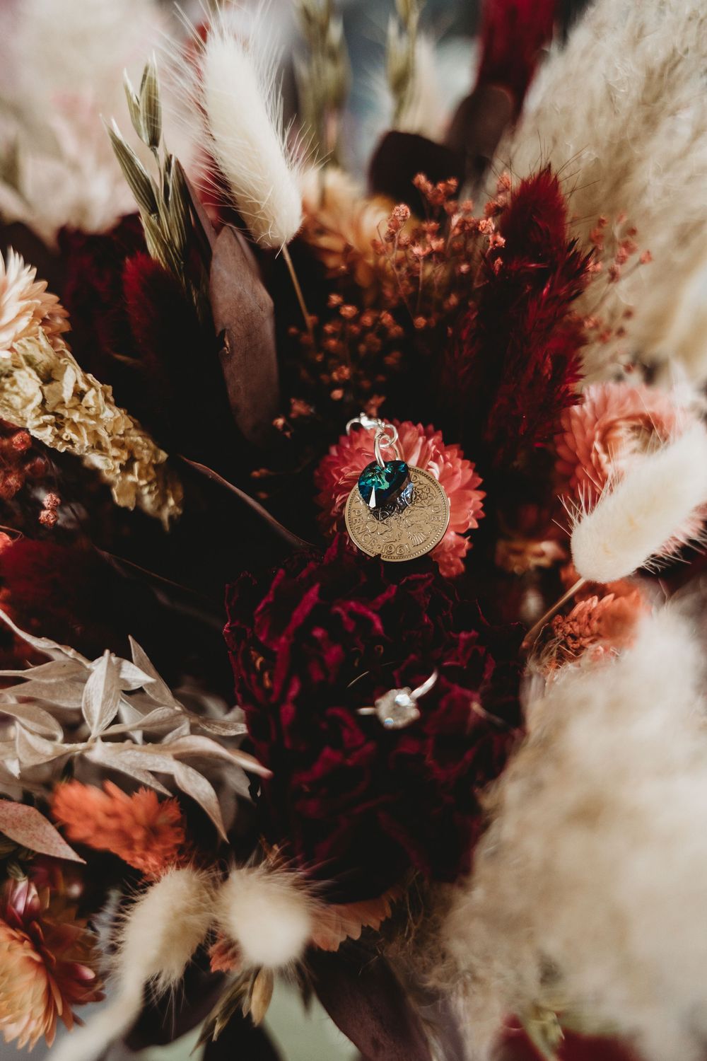 Dramatic dried flower bouquet with deep red and white tones in moody lighting.