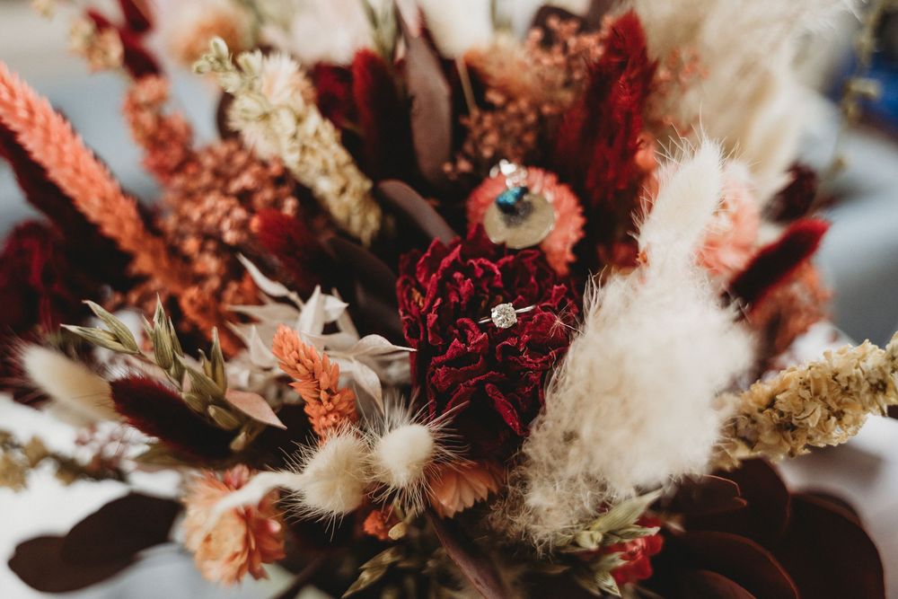 Dried flower arrangement with pampas grass and burgundy blooms in macro detail.